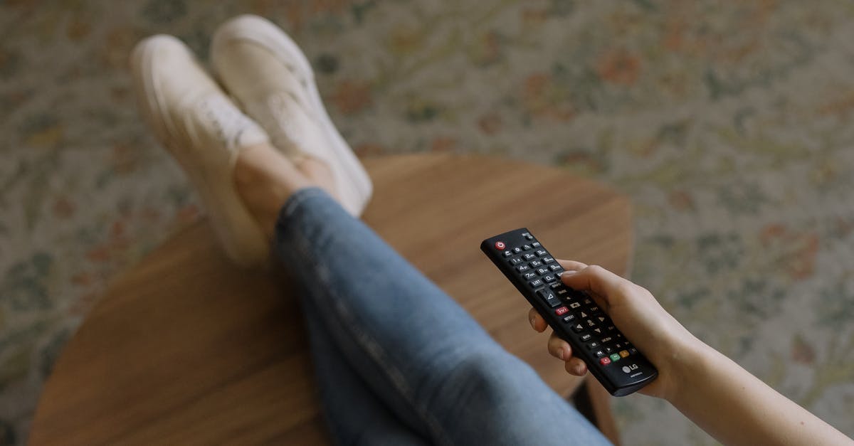 Controllers disconnecting from console - Person in Blue Denim Jeans and White Socks Sitting on Brown Wooden Floor