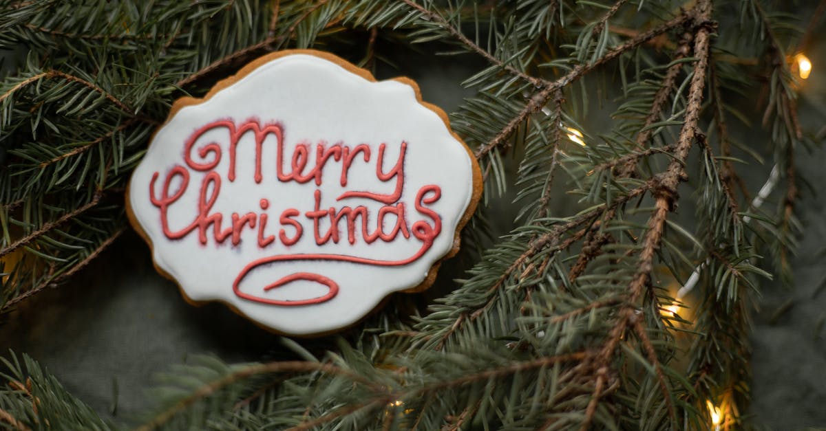 Cookie Clicker- [Last chance to see] and [All natural sugar cane] shadow achievements - From above of yummy gingerbread cookie with inscription on sugar glaze between spruce sprigs with shiny garland during New Year holiday
