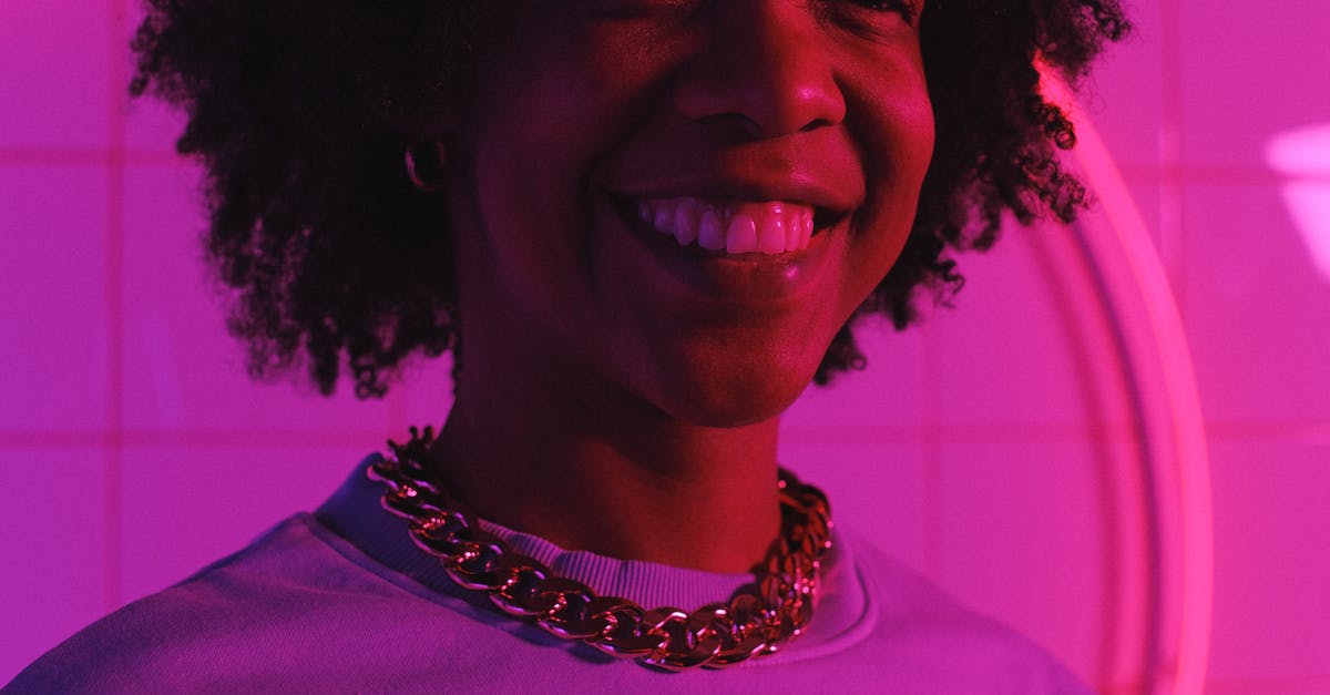 Cooling an insulated tile? - Crop smiling ethnic female teen in necklace with Afro hairstyle looking away in neon light against tiled wall Cooling an insulated tile? - Crop smiling ethnic female teen in necklace with Afro hairstyle looking away in neon light against tiled wall