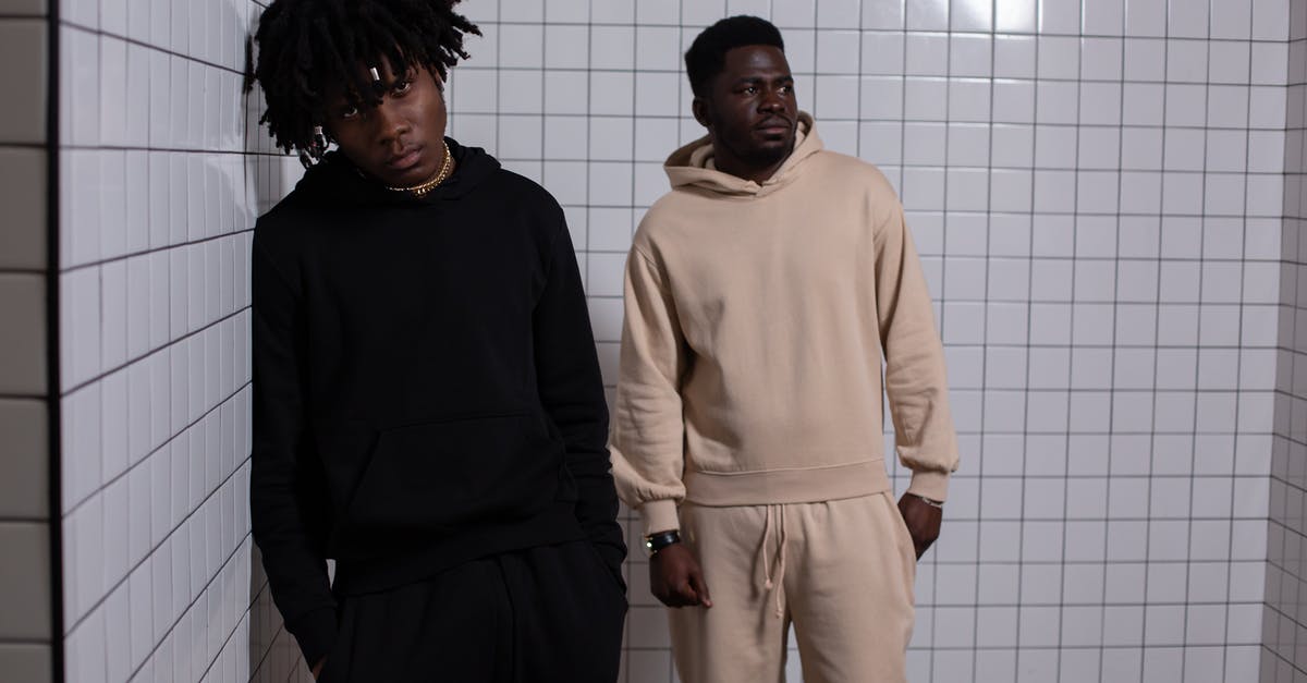 Cooling an insulated tile? - Confident African American males in comfy clothes standing with hands in pockets in tiles room Cooling an insulated tile? - Confident African American males in comfy clothes standing with hands in pockets in tiles room