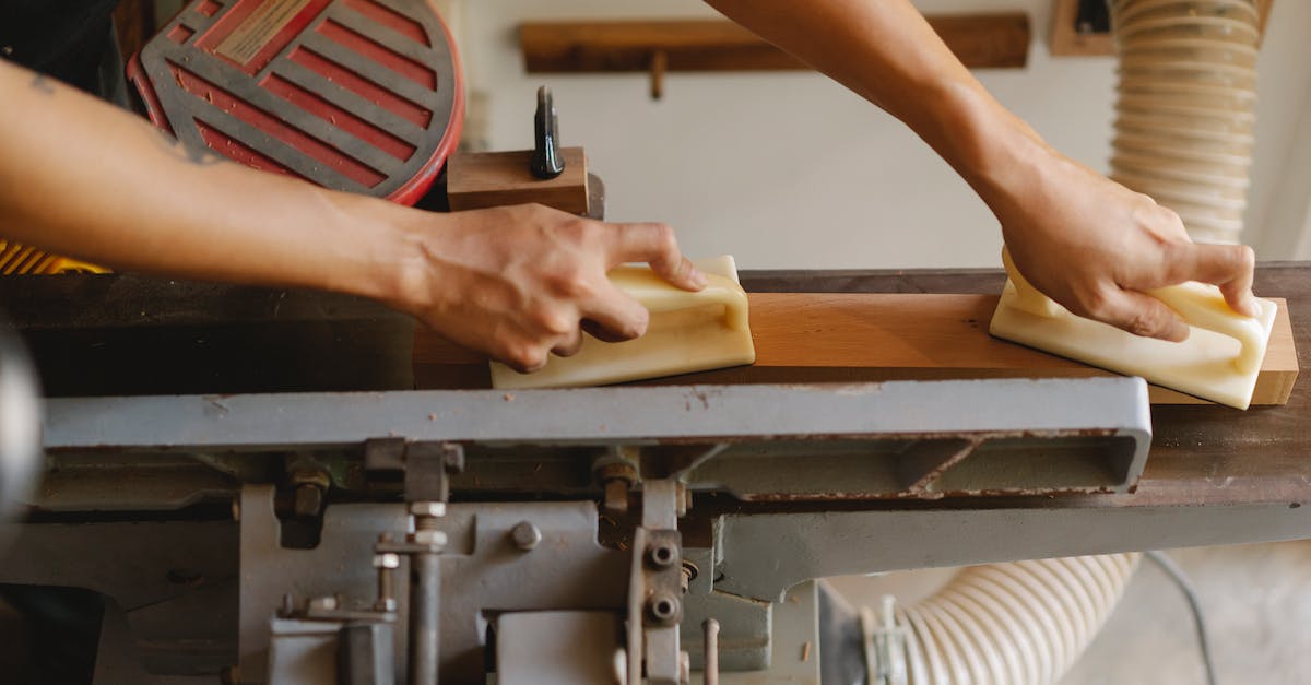 Cost efficient enchanting profession levelling - From above of crop anonymous woodworker leveling timber on professional equipment using manual instruments in workroom in daylight Cost efficient enchanting profession levelling - From above of crop anonymous woodworker leveling timber on professional equipment using manual instruments in workroom in daylight