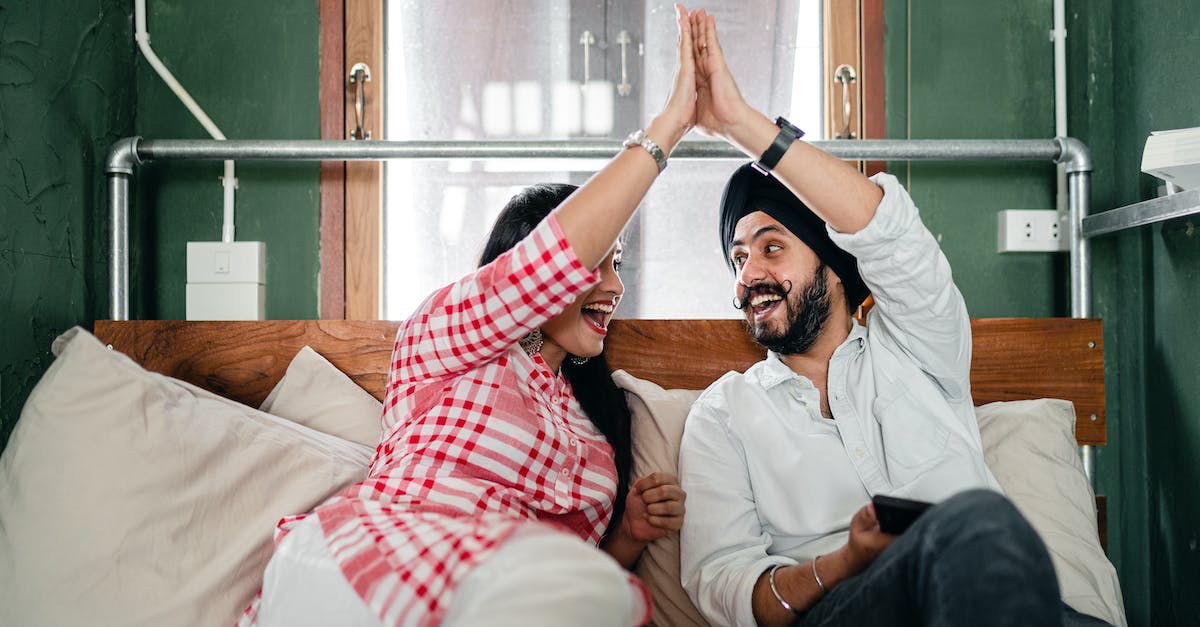 Could you pipe items In and Out of the AE grindstone? - Positive adult ethnic couple in casual clothes giving high five to each other while resting on bed in small bedroom with sticking out pipe
