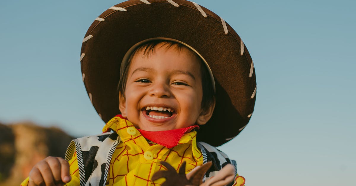 Cowboy with an odd accent - Child in Yellow and Blue Stripe Shirt Wearing Brown Hat