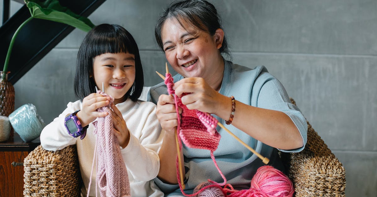 Crafting a greatsword Help - Cheerful little Asian girl with grandmother knitting with needles while sitting together on wicker armchair at home Crafting a greatsword Help - Cheerful little Asian girl with grandmother knitting with needles while sitting together on wicker armchair at home
