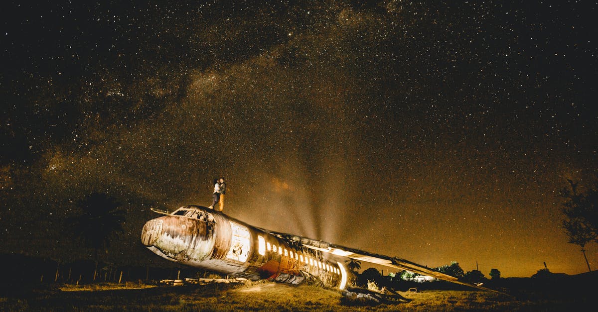 Crashed when storing Pokémon - Anonymous couple of travelers embracing on abandoned plane at dusk Crashed when storing Pokémon - Anonymous couple of travelers embracing on abandoned plane at dusk
