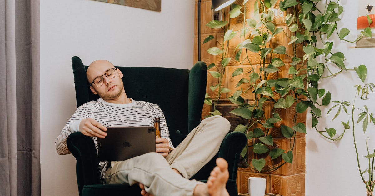 Crashing while Investigating Ivy's Plant - Man Sitting on a Green Velvet Armchair in an Interior with a Tiled Stove and Abstract Paintings Crashing while Investigating Ivy's Plant - Man Sitting on a Green Velvet Armchair in an Interior with a Tiled Stove and Abstract Paintings