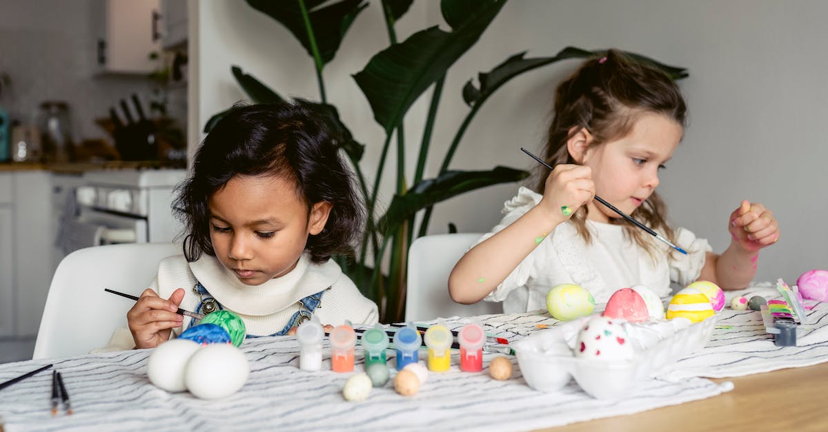 Creating a chest with a specific spawn egg inside - Concentrated multiracial girls painting eggs with paintbrushes while sitting at table with set of paints in kitchen during Easter holiday preparation Creating a chest with a specific spawn egg inside - Concentrated multiracial girls painting eggs with paintbrushes while sitting at table with set of paints in kitchen during Easter holiday preparation
