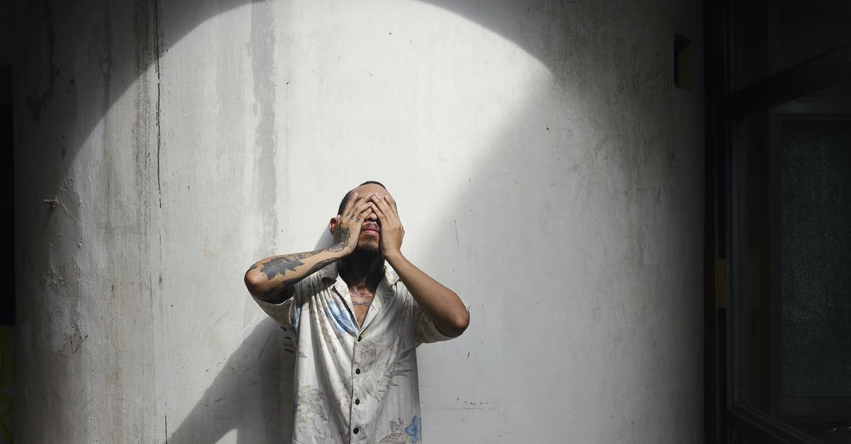 Custom Data model shows old textures but slighty darkened - Young man with short brown hair and tattoos on arm in shirt standing near white wall and closing eyes with hands Custom Data model shows old textures but slighty darkened - Young man with short brown hair and tattoos on arm in shirt standing near white wall and closing eyes with hands