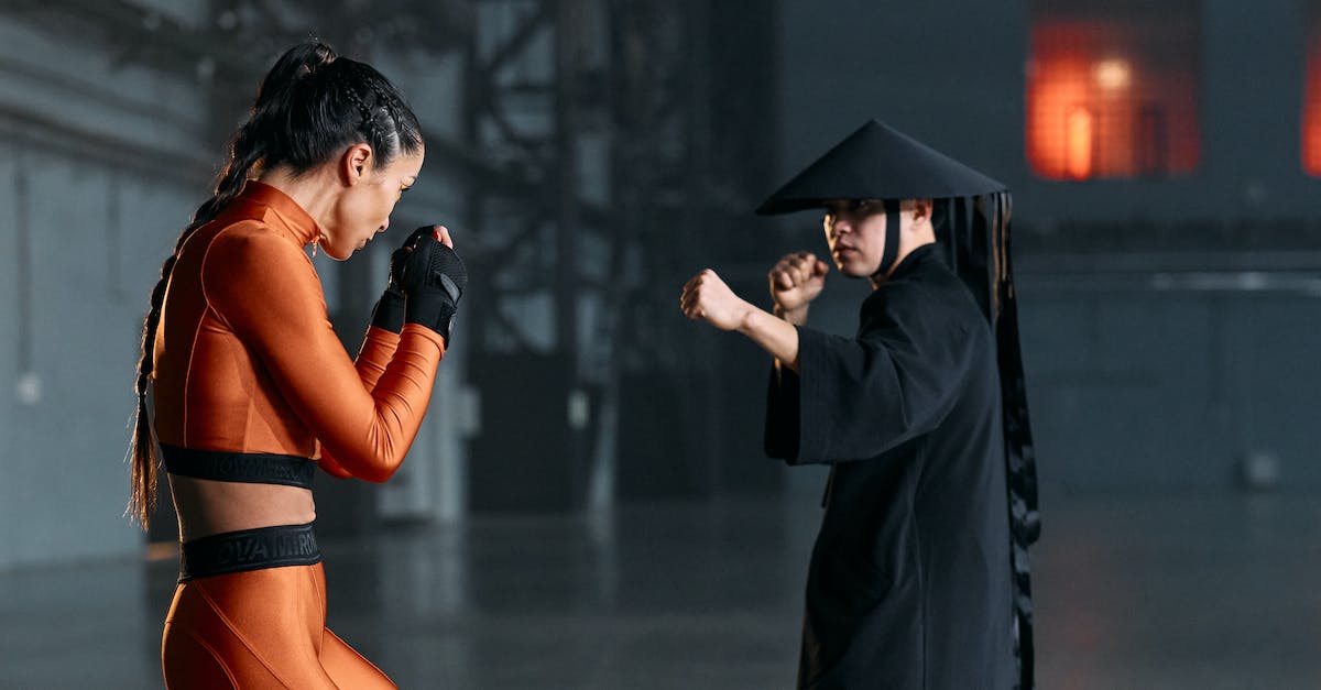 Cycling through attack modifiers in Dota 2 - Woman in Orange Long Sleeve Shirt Standing beside a Man in Black Long Sleeve Dress Shirt