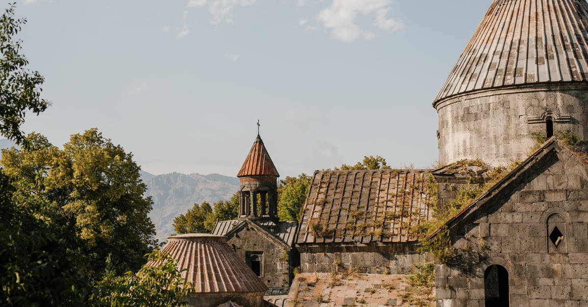 Damage mitigation in God of War series - Aged stone building of cathedral with shabby walls and moss on tiled roof in old village Damage mitigation in God of War series - Aged stone building of cathedral with shabby walls and moss on tiled roof in old village