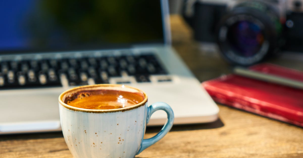 Dark Souls 3: How to press OK? - A cup of coffee and a camera on a wooden table  in the workplace
