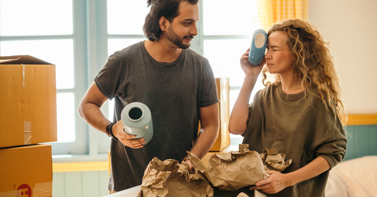 Death Stranding Doesn't Open - Satisfied adult bearded ethnic man and playful woman with curly hair wearing casual t shirts unboxing ceramics for home decoration from carton boxes while moving in new apartment