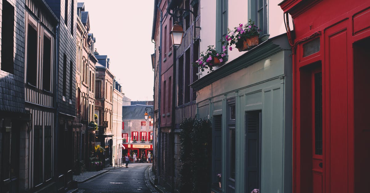 Dependence between spells and spellpower - Paved road on narrow alley between residential building with colorful facade and windows located in town on street against cloudless sky