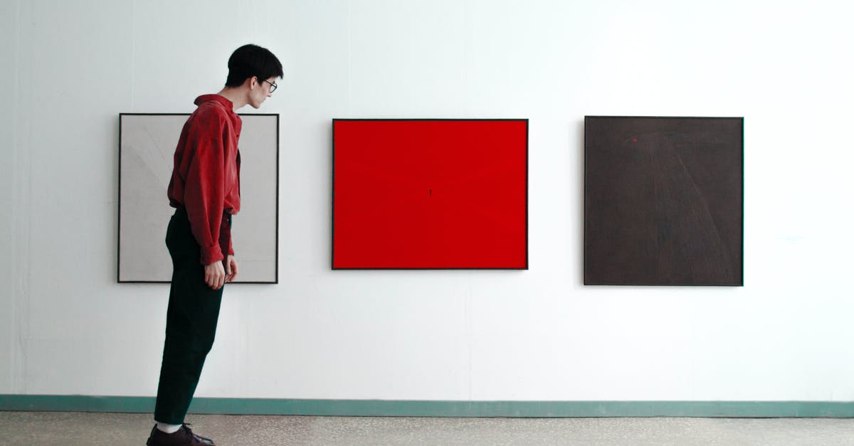 Difference between tilted and triggered? - Man Standing Tilted and Looking at Modern Art Pictures 