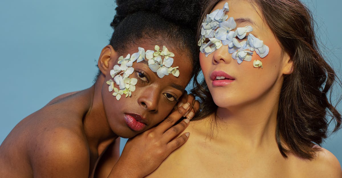 Different sensitivity when zooming in - Diverse women with gentle blue petals of flower on face Different sensitivity when zooming in - Diverse women with gentle blue petals of flower on face