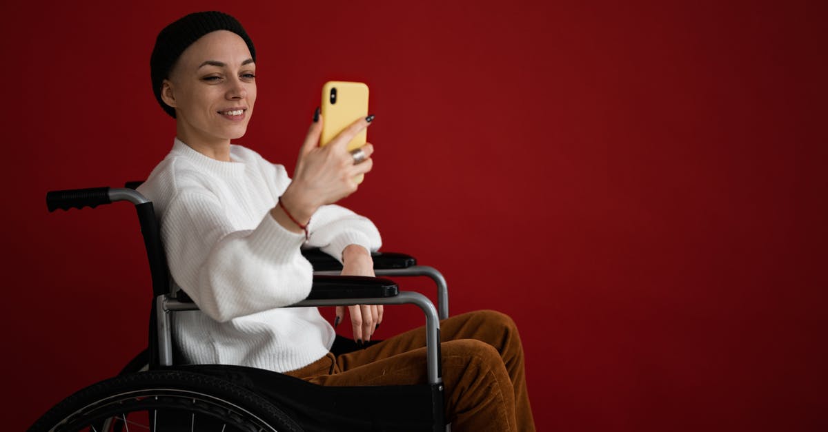 Disable Steam Guard email, but not phone guard? - Side view of young positive female in casual clothes and hat sitting in wheelchair while texting on phone in light studio on red background Disable Steam Guard email, but not phone guard? - Side view of young positive female in casual clothes and hat sitting in wheelchair while texting on phone in light studio on red background