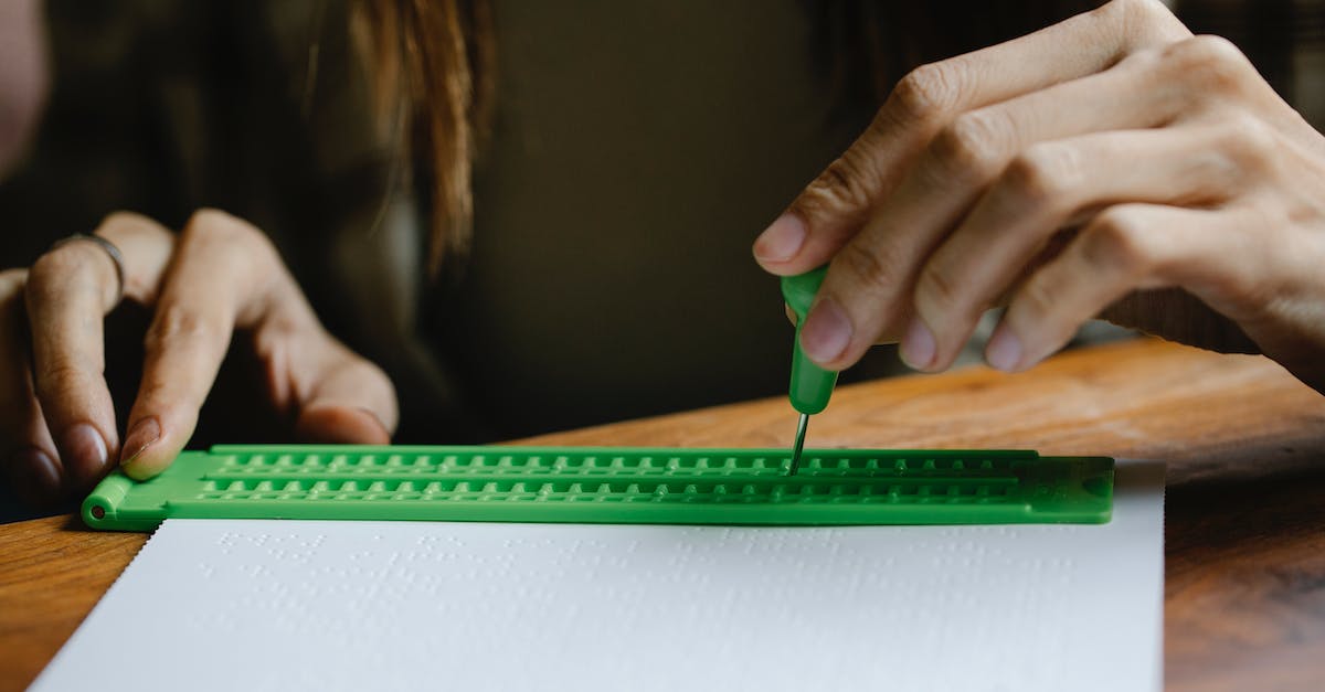 Disable warmup text/make it less distracting - Crop anonymous person with vision loss writing braille letter with slate and stylus