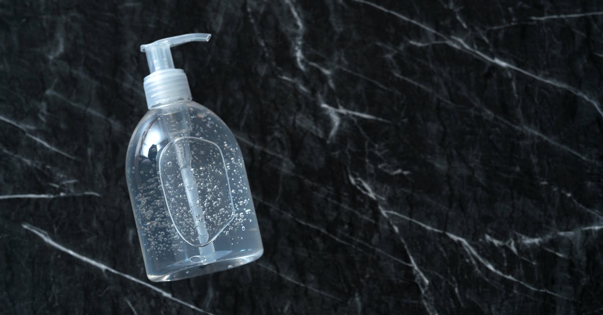 Dispenser stops shooting items when full - Top view of plastic bottle with antibacterial gel on dark table during COVID 19 pandemic
