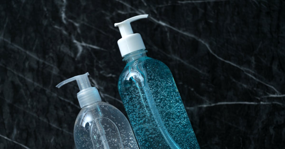 Dispenser stops shooting items when full - Top view of transparent plastic bottles with antibacterial gel and liquid soap during quarantine period