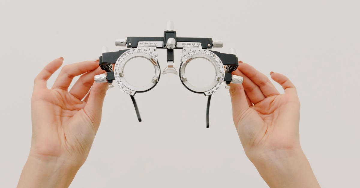 Divinity immaculate trial - Crop unrecognizable female demonstrating modern trial frame with optical lenses against white background in optometrist studio