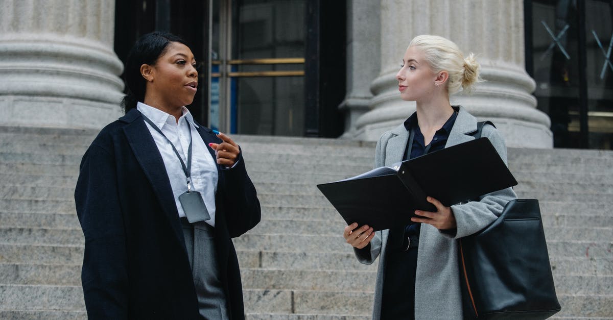 Divinity immaculate trial - Elegant diverse female business partners with documents talking on street