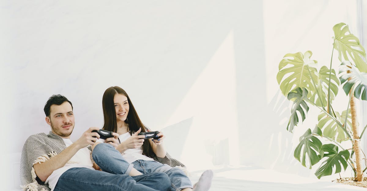 Do all Playstation consoles use 3.3V for controller port signalling? - Content man in jeans with game pad lying near positive girlfriend on bed near potted plant on sunny day while entertaining together