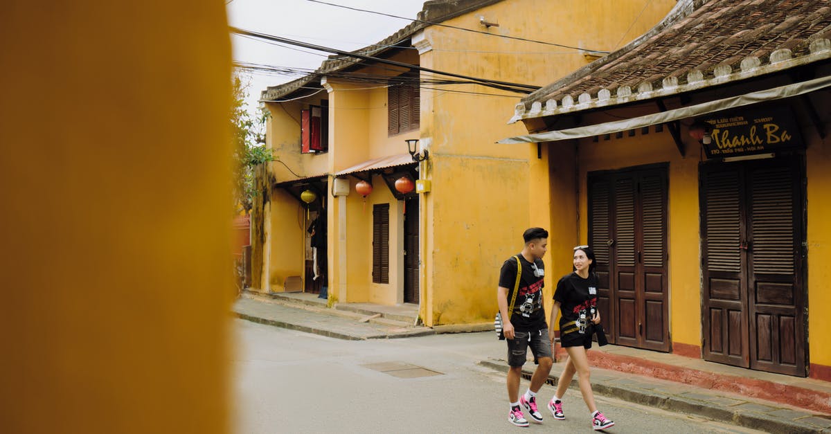Do any heroes share romantic relationships with other heroes? - Full length positive young ethnic couple in casual clothes strolling together on typical Asian street and having conversation Do any heroes share romantic relationships with other heroes? - Full length positive young ethnic couple in casual clothes strolling together on typical Asian street and having conversation