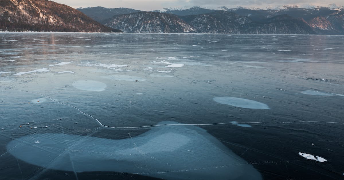 Do different mounts change your mounted cloak size? - Picturesque mountains and icy lake with blots on surface Do different mounts change your mounted cloak size? - Picturesque mountains and icy lake with blots on surface