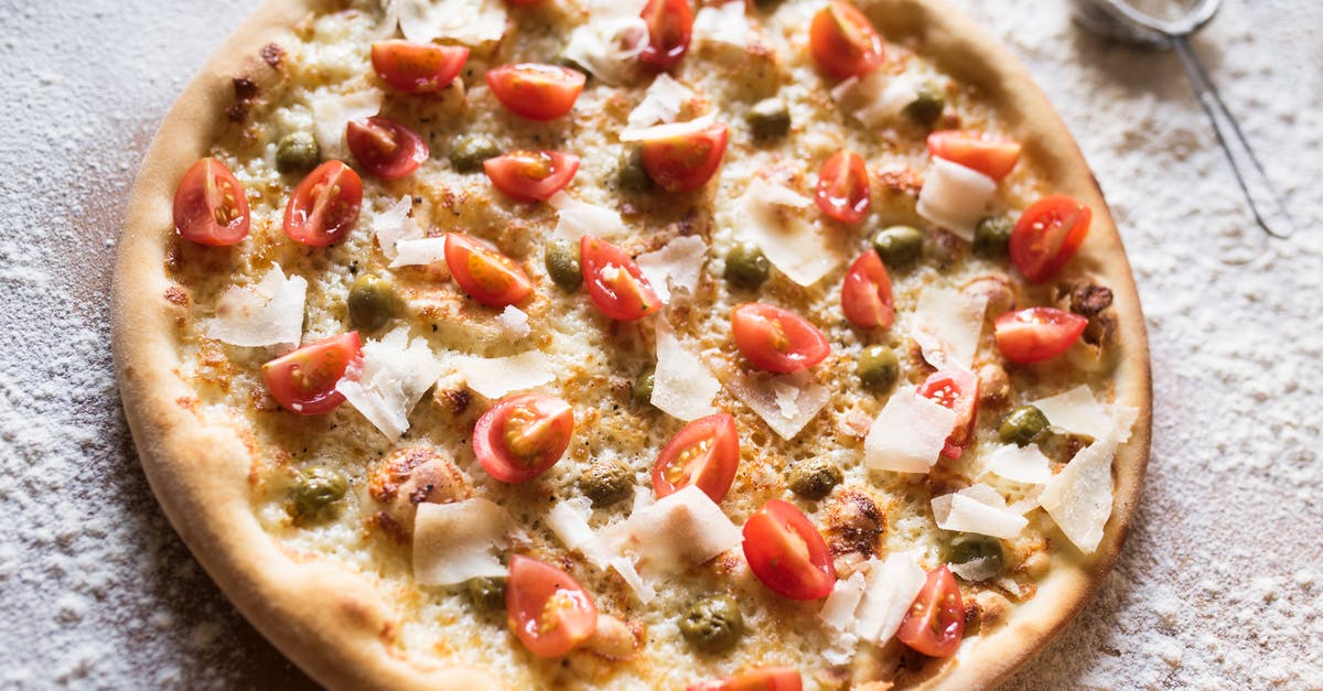 Do guards always spill the juicy details first? - From above of yummy pizza with pickled capers and fresh tomato slices on table with spilled flour