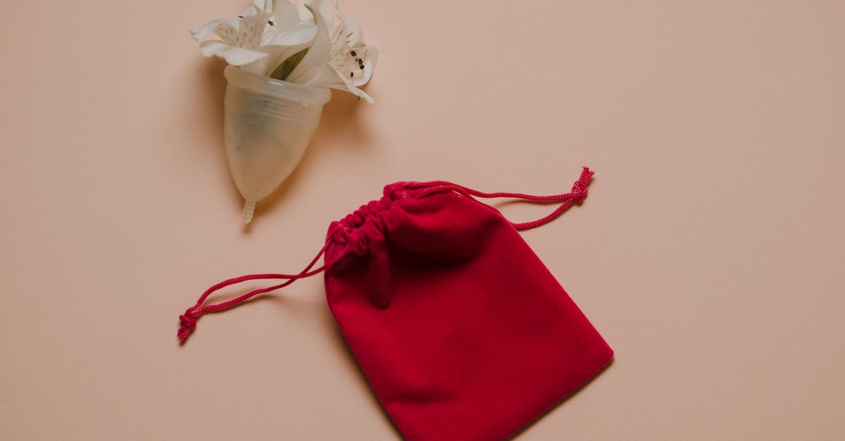 Do incapacitated soldiers with bleeding wounds need any extra care? - Menstrual cup with white gentle flowers placed on pink surface near bag
