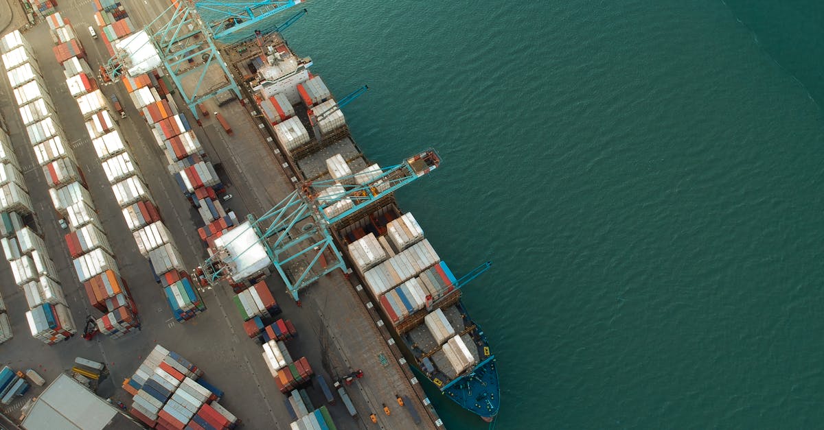 Do logistic drones and vessels carry goods roundtrip? - Top view of harbor with containers and cargo ships located near calm rippling sea water Do logistic drones and vessels carry goods roundtrip? - Top view of harbor with containers and cargo ships located near calm rippling sea water
