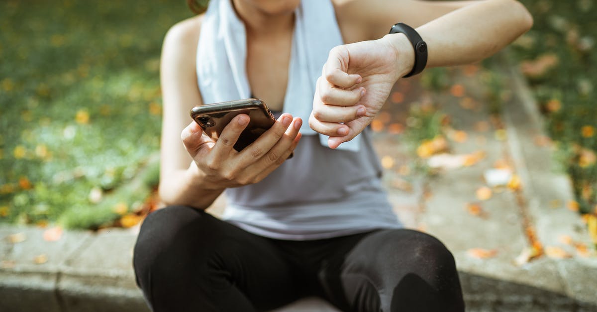 Do more pokemons spawn if your the app is active - Anonymous female in sportswear using smartphone and smart watch after exercising on sports ground Do more pokemons spawn if your the app is active - Anonymous female in sportswear using smartphone and smart watch after exercising on sports ground