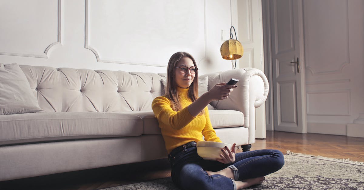 Do my vault dwellers eat more when I watch them? - Young woman relaxing at home and watching movie Do my vault dwellers eat more when I watch them? - Young woman relaxing at home and watching movie