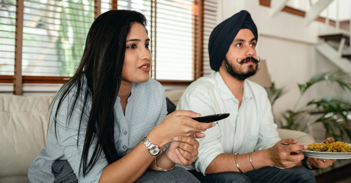 Do my vault dwellers eat more when I watch them? - Serious ethnic couple watching movie on sofa Do my vault dwellers eat more when I watch them? - Serious ethnic couple watching movie on sofa