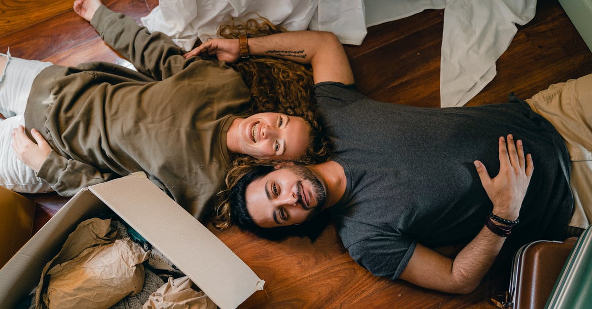 Do non-player-entities affect move-staling? - From above of young smiling diverse couple in casual clothing relaxing on floor near carton boxes while unpacking belongings in new contemporary apartment