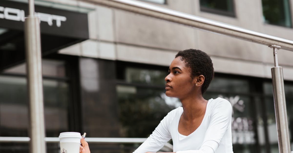 Do Pokémon kicked from gyms go away forever? - Serious African American female with short hair sitting at table with disposable cup of hot drink and looking away