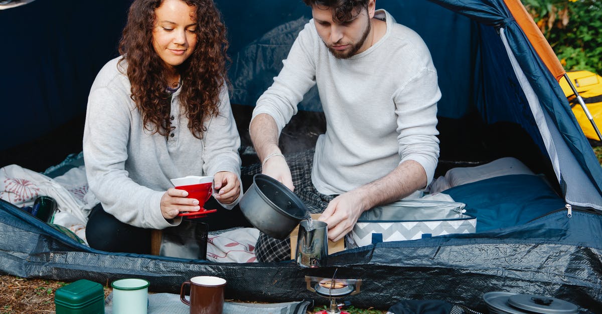 Do relationships degrade over time? - Crop couple of travelers preparing coffee in tent