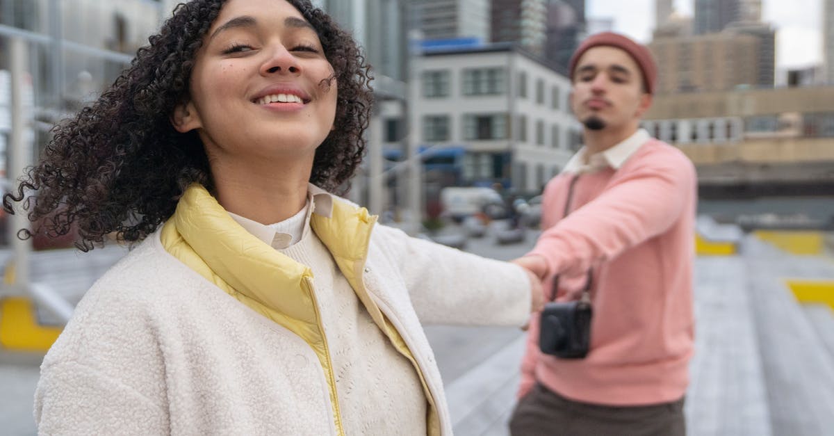 Do Shrines affect Followers? - Cheerful Hispanic couple with photo camera holding hands