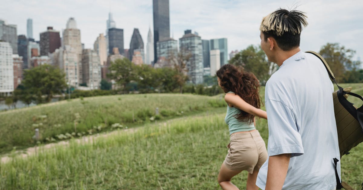 Do Shrines affect Followers? - Side view of unrecognizable young female tourist holding hand of boyfriend and running in city park during romantic date in New York