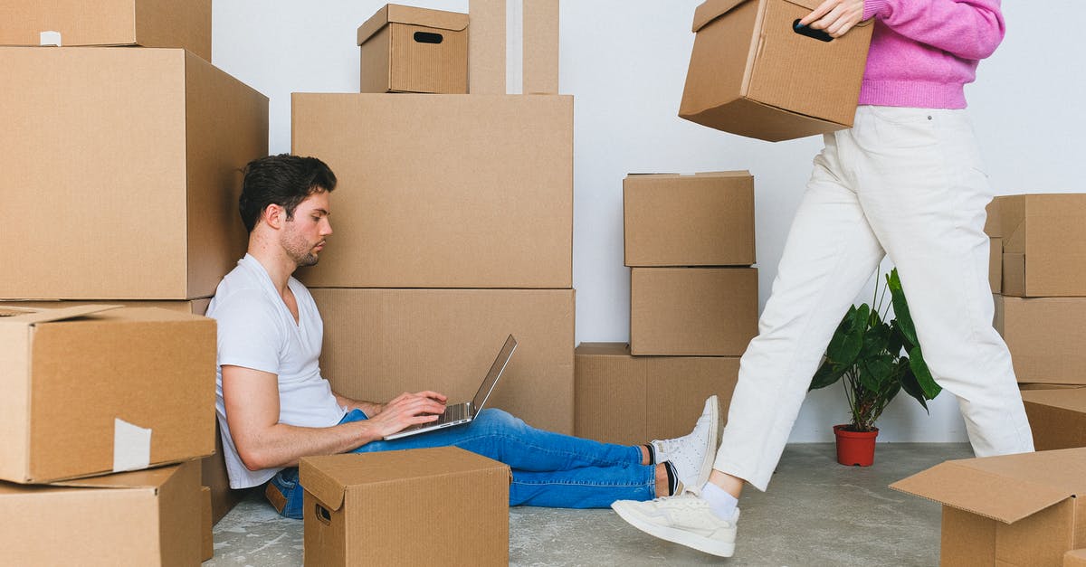 Do side quests reset in New Game+? - Crop woman arranging carton boxes during relocation with boyfriend using laptop on floor