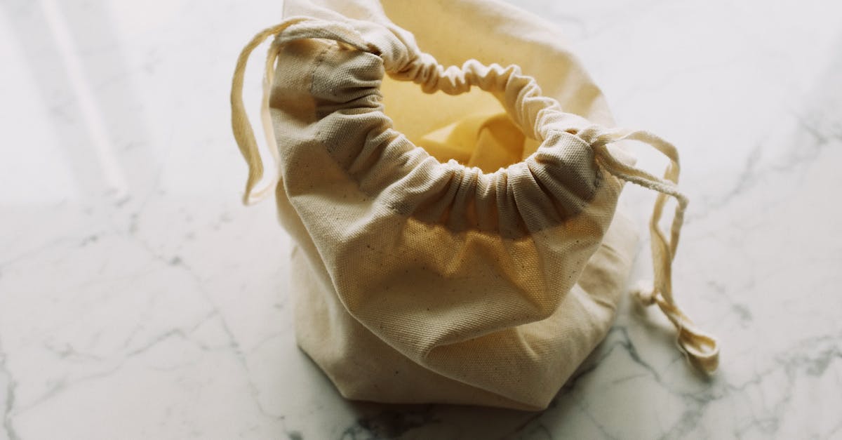 Do skins exterior quality reduce from use? [duplicate] - Top view of plain white fabric sack with drawstrings placed on marble table in room