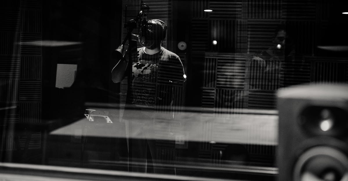 Do standard headphones work with the XBox 360 controller? - Through glass of black and white anonymous male musician in headphones singing with microphone while recording song in modern studio Do standard headphones work with the XBox 360 controller? - Through glass of black and white anonymous male musician in headphones singing with microphone while recording song in modern studio
