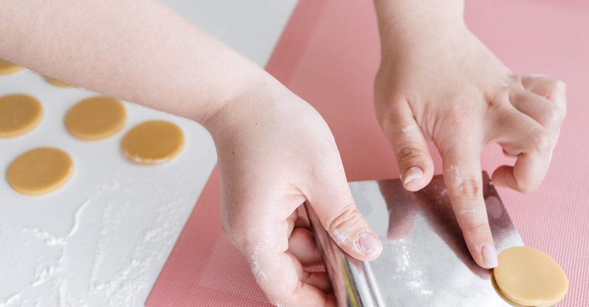 Do stronger Conjuration spells make weaker bodies stronger? - Crop woman placing unbaked cookies on baking mat