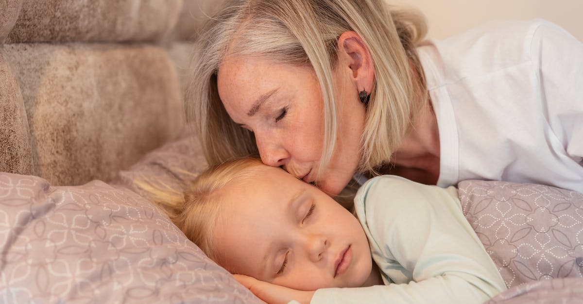 Do Super Mutants Sleep? - Woman in White Long Sleeve Shirt Carrying Baby in White Long Sleeve Shirt