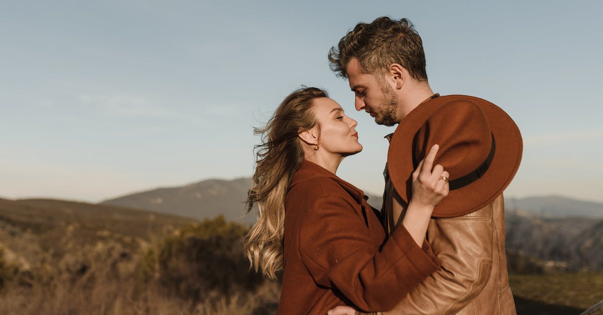 Do the 'Augment X' skills affect 'X-Touched' damage? - Couple Embracing and Looking at Each Other with Hills in the Background