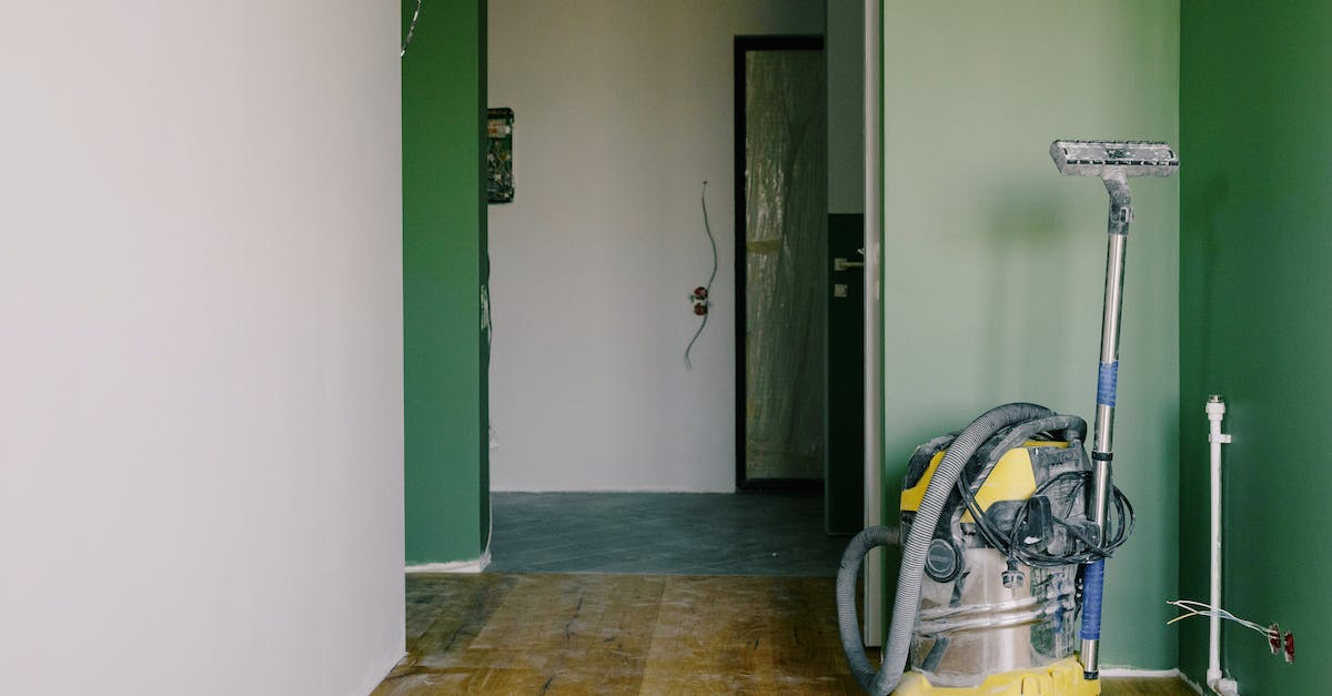 Do the alternate floors permenantly replace the originals? - Industrial vacuum cleaner placed on dirty parquet in room with green walls and doorway in spacious apartment during repair works