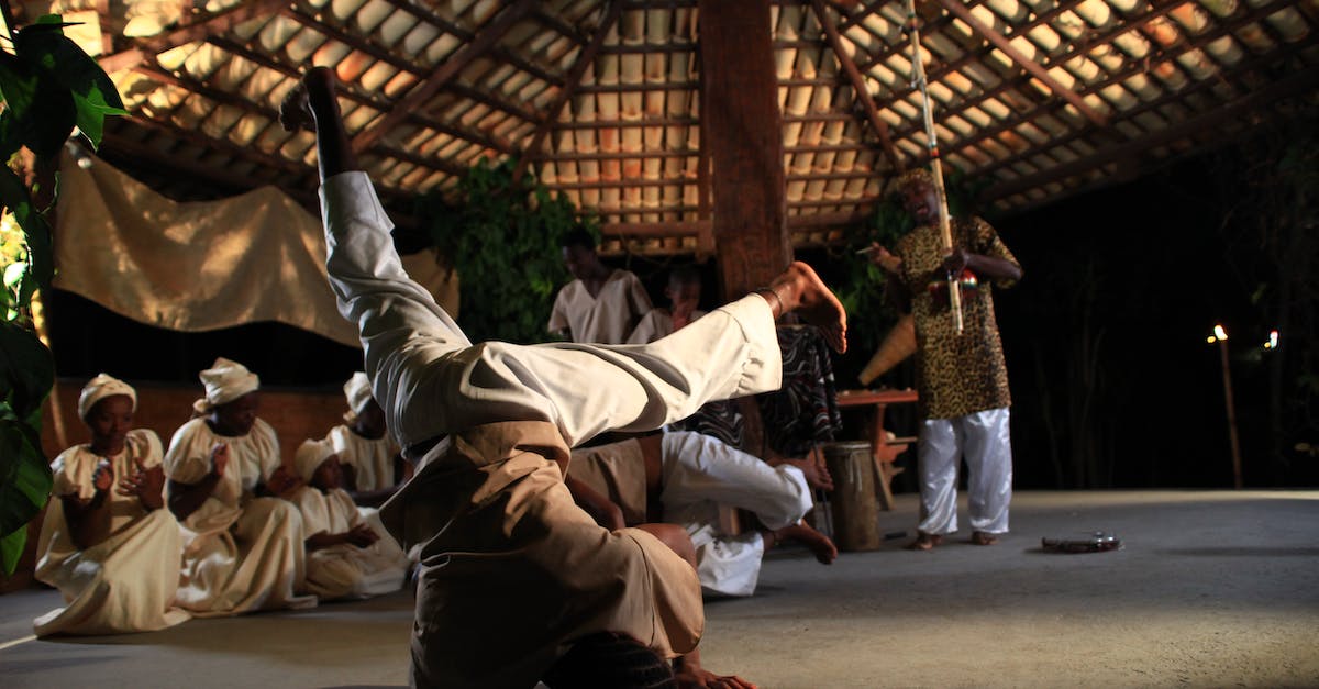 Do the villagers ever succeed in the action they're attempting? - Full body of African man dancing on head during traditional ceremony in village Do the villagers ever succeed in the action they're attempting? - Full body of African man dancing on head during traditional ceremony in village
