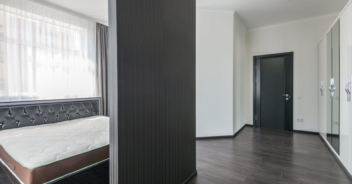 Do wooden beams separate NPC's houses? - Interior of modern white apartment with comfortable furniture and soft bed with wooden parquet in daylight