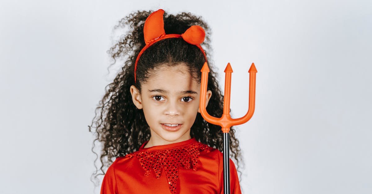 Do you earn less XP per character with a larger party? - Adorable African American child with long curly hair showing artificial trident while standing in white studio in red Halloween costume of devil