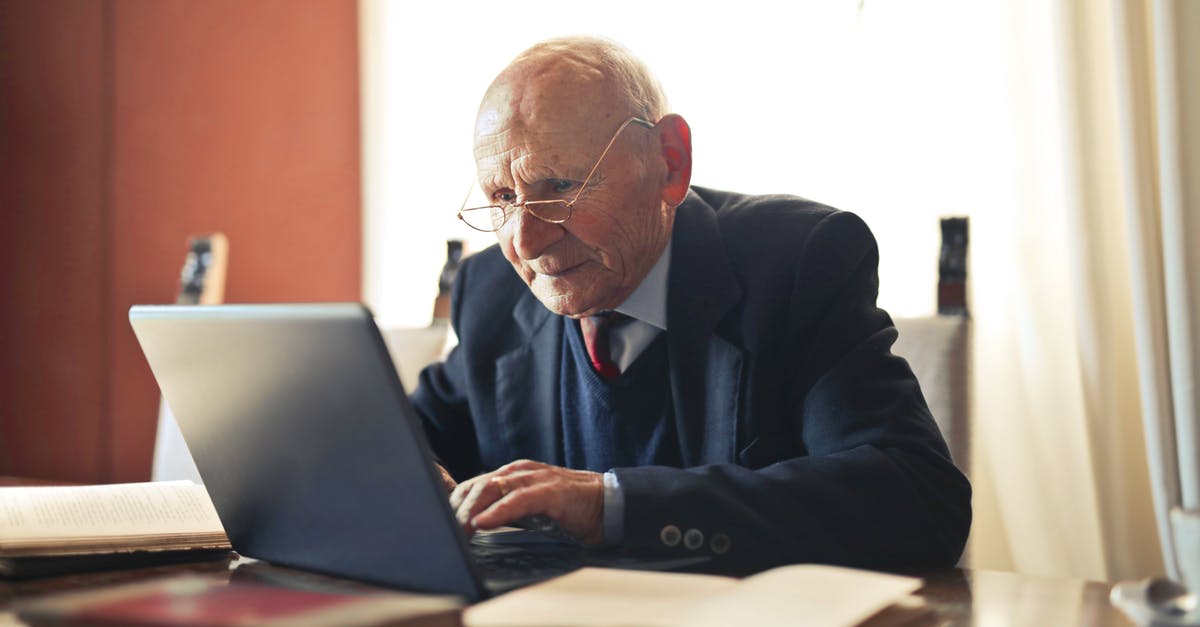 Do you have any experience with Pokémon GO and slow internet? - Concentrate elderly senior man in formal suit and eyeglasses working on laptop while sitting at wooden table with books in light room Do you have any experience with Pokémon GO and slow internet? - Concentrate elderly senior man in formal suit and eyeglasses working on laptop while sitting at wooden table with books in light room
